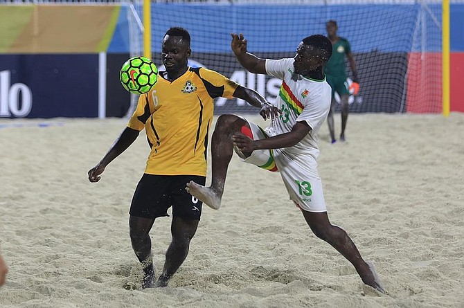 Gary Joseph, of the Bahamas, tussles for the ball against Guadeloupe on Friday night in the CONCACAF Beach Soccer Championship quarter-final at Malcolm Park West