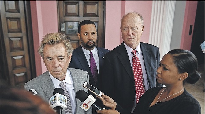 Michael Scott speaking to the media at a previous court appearance - with Dr Andre Rollins and Richard Lightbourn watching on.