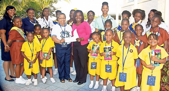 Sunflowers, Brownies, Guides, Rangers and their leaders toured LPIA to explore careers in the fields of science and technology. Pictured in the centre is Anita Bernard, President of the Bahamas Girl Guide Association accepting a cheque from Elizabeth Ferguson, Duty Supervisor and tour guide at NAD.

