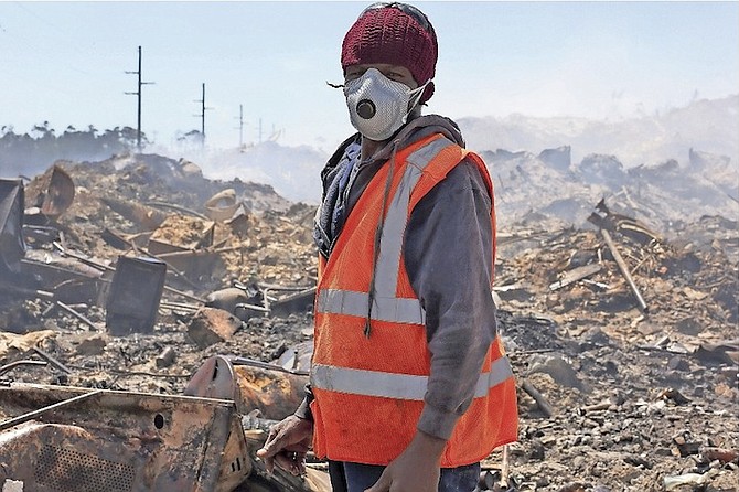 A worker in a protective mask at the dump fire.
Photo: Terrel W. Carey/Tribune Staff