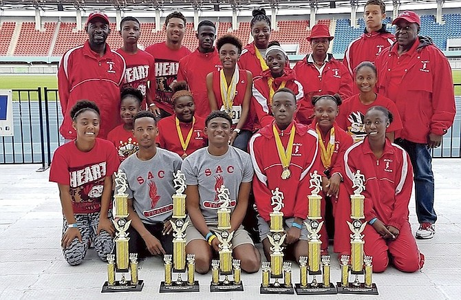SAC students show off their medals and trophies won at the 28th National High School Track and Field Championships. Standing in the back (far left) is assistant coach Tito Moss. At right is head coach William Johnson and  third from right is principal Sonia Knowles.