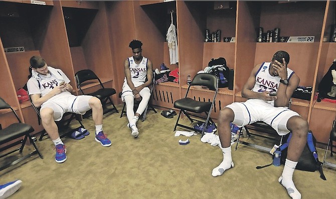 Kansas’ Dwight Coleby, right, Sviatoslav Mykhailiuk (at far left) and Lagerald Vick sit in the locker room after the team’s Midwest Regional final against Oregon in the NCAA college basketball tournament Saturday in Kansas City, Mo. Oregon won 74-60. (AP Photo/Orlin Wagner)
