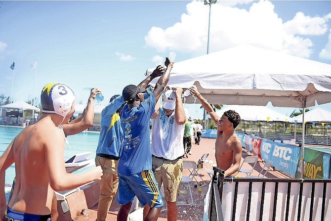 Team Bahamas’ water polo team members celebrate their gold and silver triumph by dousing their coach.
 Photo: Shawn Hanna/Tribune Staff