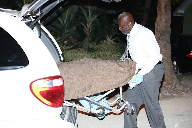 The body of the dead man is removed from the scene in Knowles Drive on Saturday night. Photo: Terrel W Carey/The Tribune