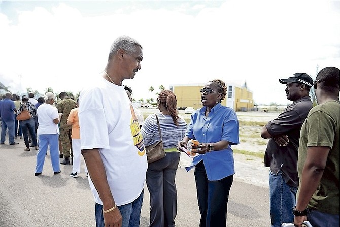 Leslie Miller speaking to people queuing for advanced polling yesterday. Photo: Shawn Hanna/Tribune Staff