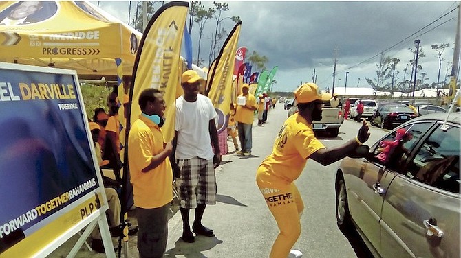 A PLP supporter greets a passing motorist outside Police Training College in Grand Bahama yesterday. 