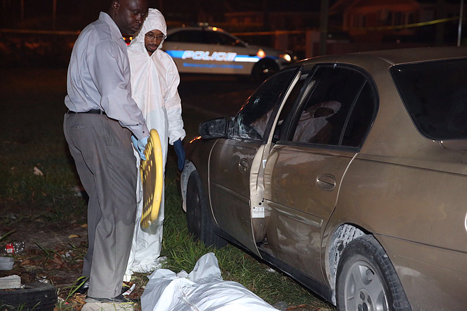 Investigators at the scene of the fatal shooting of a man in a car at Whitaker Close early on Friday. Photo: Terrel W Carey/Tribune Staff 

