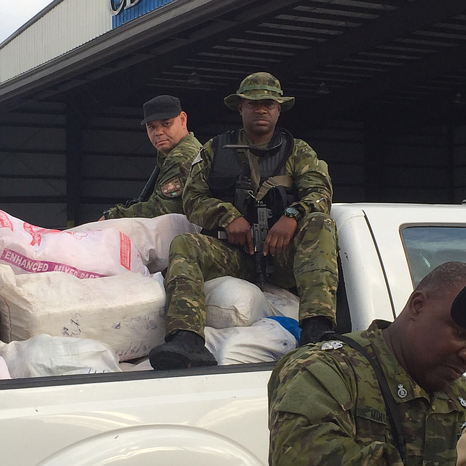 Officers in South Andros with some of the seized nylon sacks of marijuana on Thursday