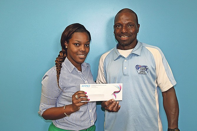 Ajna Darling, public relations associate at BTC, presents Mario Ford, founder of the Mario Ford Baseball Camp, with a cheque.
