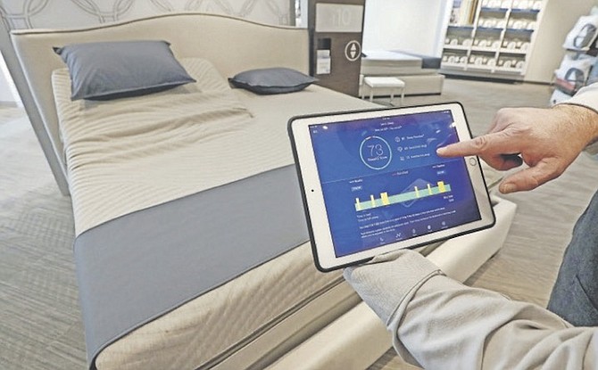 Sleep Number store manager Lee Pulliam demonstrates how the company’s sleep technology tracks your sleeping patterns. (AP)