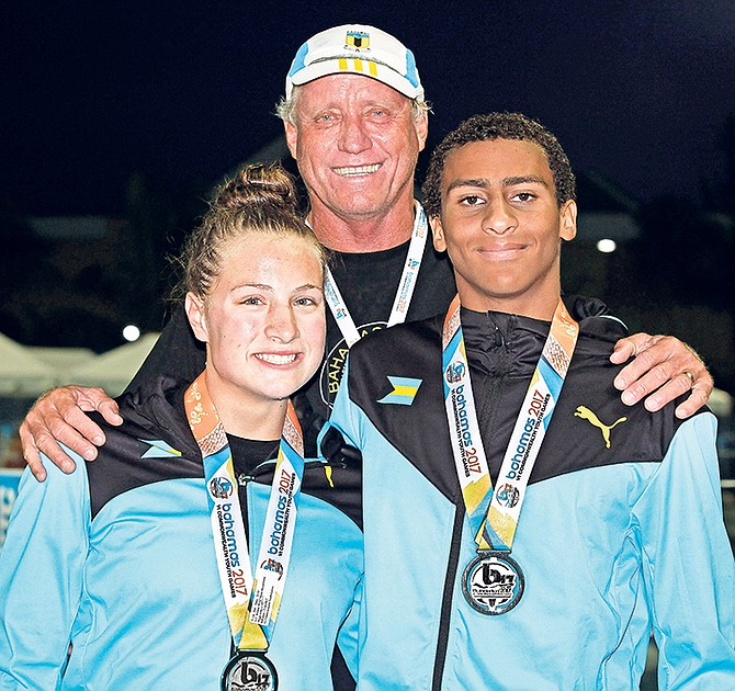 SILVER STARS: Lilly Higgs and Izaak Bastian (with proud heach coach Andy Knowles) display their silver medals won yesterday in the 50 metres breaststroke during the 6th Commonwealth Youth Games at the Betty Kelly Kenning National Swim Complex.
Photo: Derek Smith/BIS
 

