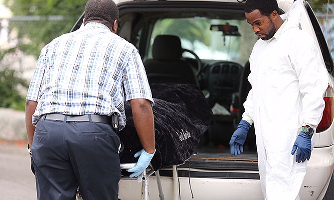 Police remove the body of the victim from the scene on Boyd Road. Photo: Terrel W Carey/Tribune staff