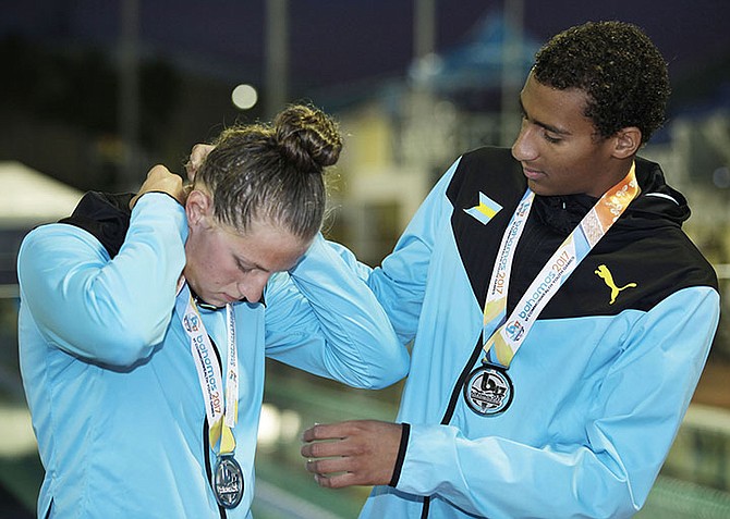 Lilly Higgs and Izaak Bastian looks over their medals. Photo: Derek Smith/BIS