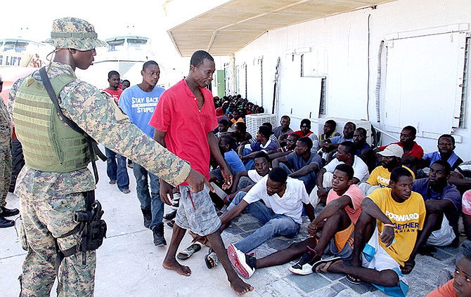 A Royal Bahamas Defence Force marine is pictured giving directions to some of the Haitian migrants at the RBDF Base on July 26. Photo: RBDF Marine Seaman Kyle Smith 