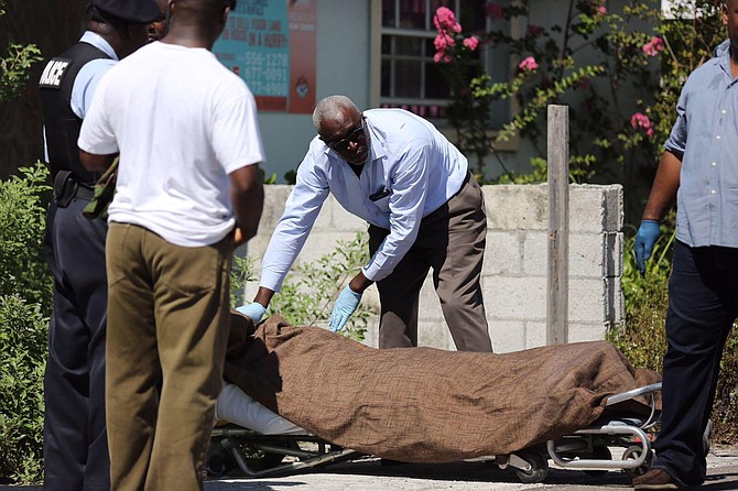 Police remove the body from the scene on Raymond Road. Photo: Terrel W Carey/Tribune staff