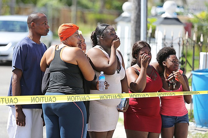 ONLOOKERS react at the scene of a fatal shooting of a young man on Saturday morning. Photo: Terrel W. Carey/Tribune Staff
