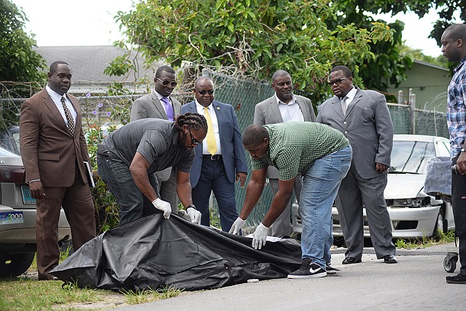 Police remove the body from the scene on Armbrister Street. Photo: Shawn Hanna/Tribune staff