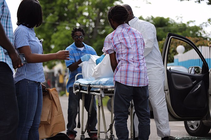 Police remove the body from the scene at Lily of the Valley Corner on Saturday. Photo: Terrel W Carey/Tribune staff