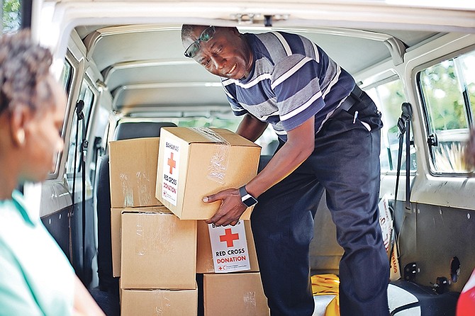Red Cross workers handing out supply boxes to persons in need yesterday. Photo: Terrel W. Carey/Tribune Staff

