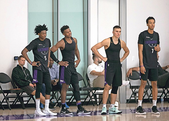 Sacramento Kings’ (from left) De’Aaron Fox, Buddy Hield, Bogdan Bogdanovic and Skal Labissiere stand on the sideline yesterday during a drill at the NBA team’s training camp in Sacramento, California. (AP)