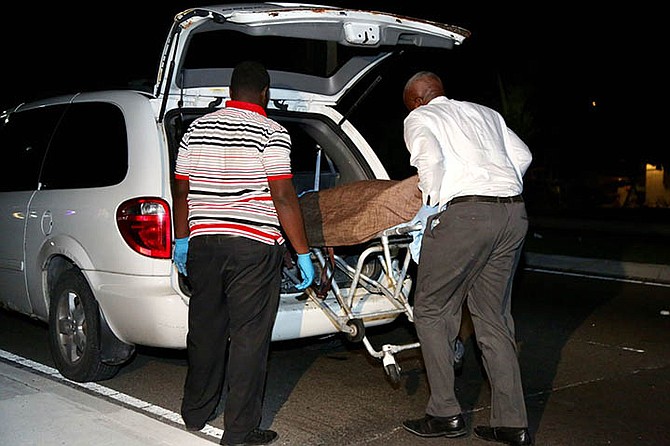 The body of the victim is removed from the scene on Tonique Williams Darling Highway.