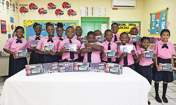 Gambier Primary students hold their new tablets yesterday after receiving them from Prime Minister Dr Hubert Minnis. Photo: Terrel W. Carey/Tribune staff