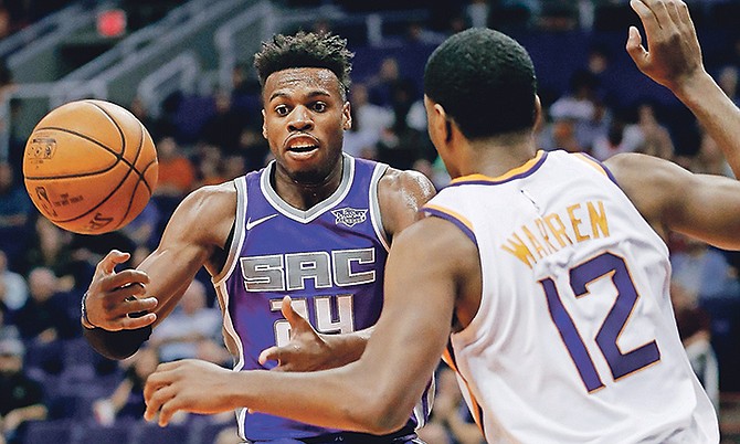 Sacramento Kings guard Buddy Hield (24) loses the ball as Phoenix Suns forward TJ Warren (12) defends during the first half of an NBA basketball game, Monday, in Phoenix. (AP Photo/Matt York)