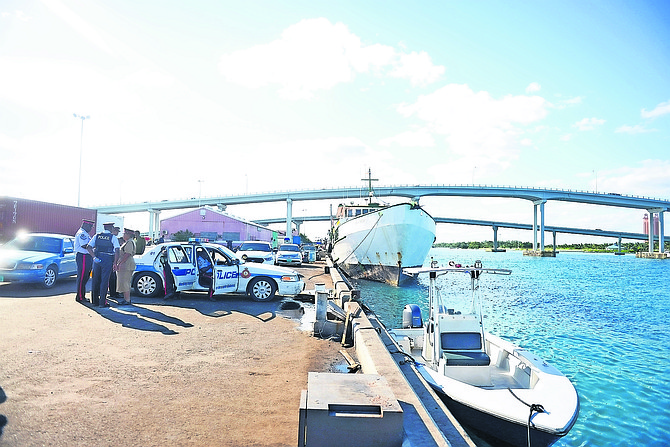 Police officers at the scene at Potter’s Cay Dock where the body of a man was found floating in the waters. Photos: Shawn Hanna/Tribune Staff
