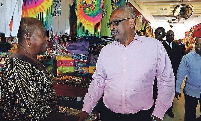 Prime Minister Dr Hubert Minnis shakes hands with one of the vendors in the straw market, during his walk through Port Lucaya Marketplace in Grand Bahama on Friday. Photo: Bahamas Information Services
