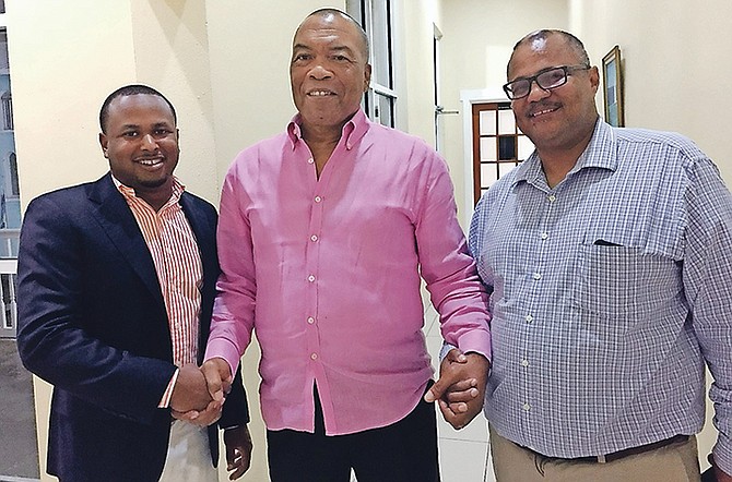 Outgoing president Wellington Miller (centre) shakes hands with new president Rommel Knowles (right) and secretary general Derron Donaldson (left).
