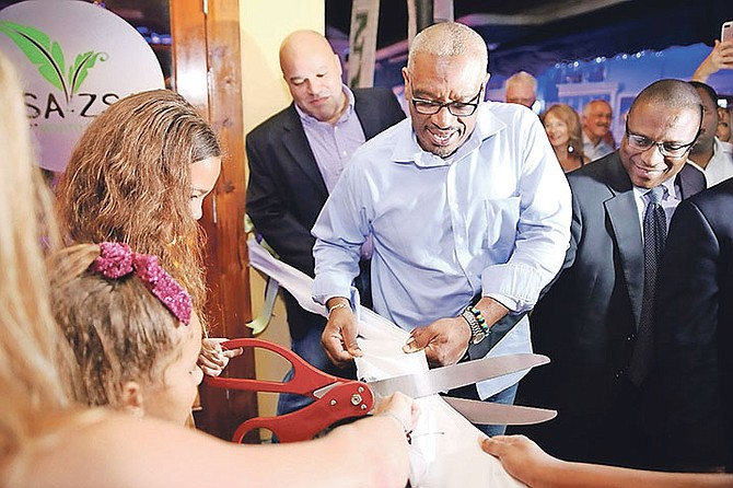 Prime Minister Dr Hubert Minnis helps to cut the ribbon to Zsa Zsa Mojito Bar alongside Minister of Youth, Sports and Culture Michael Pintard (right), on Friday. Photo: Lisa Davis/BIS
