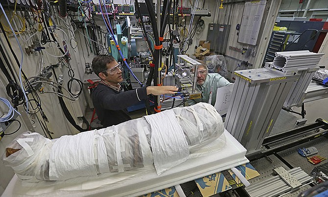 Argonne X-ray scientist Jonathan Almer, left, and Northwestern University Feinberg School of Medicine professor Stuart Stock, right, prepare to use high-energy X-ray beams to learn more about the 1,800-year-old mummified remains believed to be a 5-year-old girl in Lemont, Ill. 
(AP Photo/Teresa Crawford)

