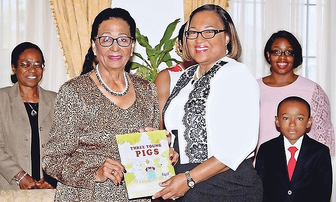 Author Lisa McCartney presents her book to Governor General Dame Marguerite Pindling.
