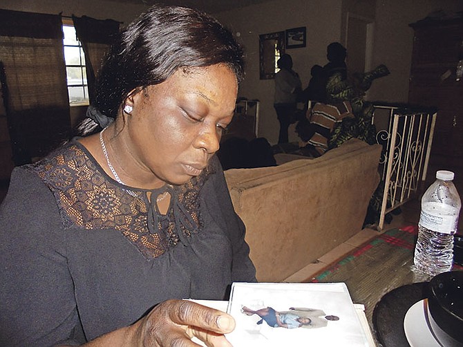 Ulean Augustine, the wife of Joel Augustine, who was killed in Grand Bahama on Monday night, looks through a photo album. 

Photo: Denise Maycock/Tribune Staff