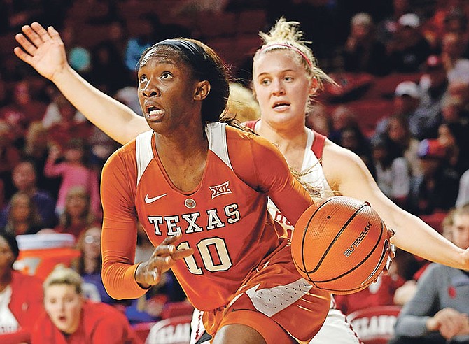 Texas’ Lashann Higgs (10), of the Bahamas, drives the ball past Oklahoma’s Ana Llanusa (22) during the first half of an NCAA college game in Norman, Oklahoma.
