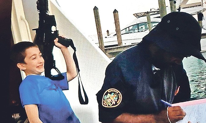 An image circulating on social media reportedly showing a youngster with an M4 automatic weapon as a tourist’s boat is being inspected by a customs officer.