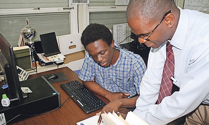 Manager of BTVI's Technical Services Wellington Bain is pictured in discussion with Office Administration student Tyric McPhee, who is a work study student in his department. Photo: Shantique Longley