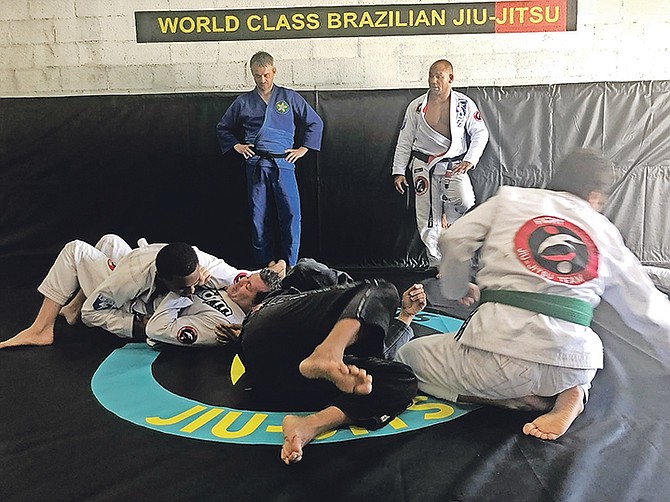 Roberto 'Cyborg' Abreu (right) watches as Jiu-Jitsu Academy members put on a demonstration.