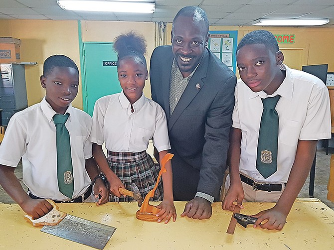 PRINCIPAL of LW Young Jr High School Stephen McPhee with students in the school’s technical
drawing workshop. From left, Ricardo Oberson, Crystal McDonald, Mr McPhee and Darron Allen.