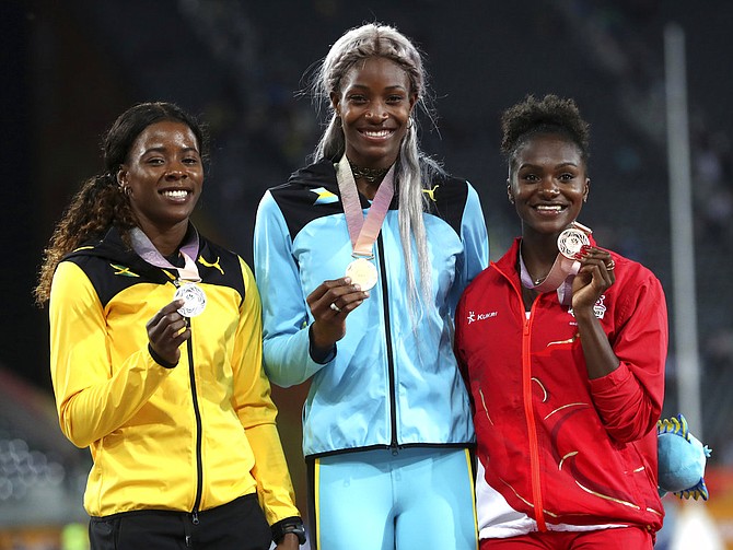 Women's 200m gold medalist Shaunae Miller-Uibo centre, stands with silver medalist Jamaica's Shericka Jackson left, and bronze medalist England's Dina Asher-Smith on the podium at Carrara Stadium during the 2018 Commonwealth Games on the Gold Coast, Australia, Thursday. (AP Photo/Mark Schiefelbein)
