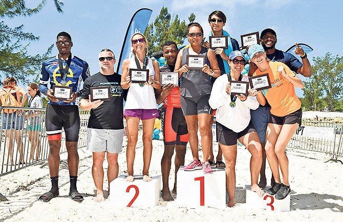 Mixed relay teams at the Potcakeman Triathlon pose above with their awards on the podium.