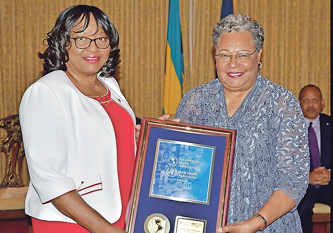 Dr Carissa Etienne, Director of the Pan American Health Organisation (left), presents Dr Merceline Dahl-Regis (right) with the Public Health Hero of the Americas Award.