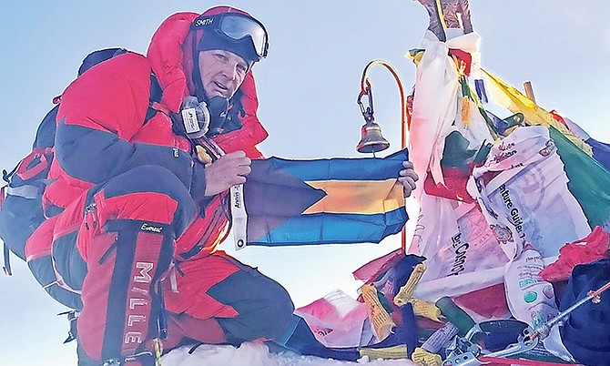 Ricard Beek unfurls the Bahamian flag at the summit of Everest.