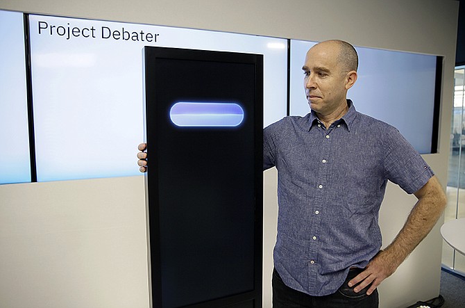 Dr Noam Slonim, principal investigator, stands with the IBM Project Debater before a debate between the computer and two human debaters. Photo: Eric Risberg/AP