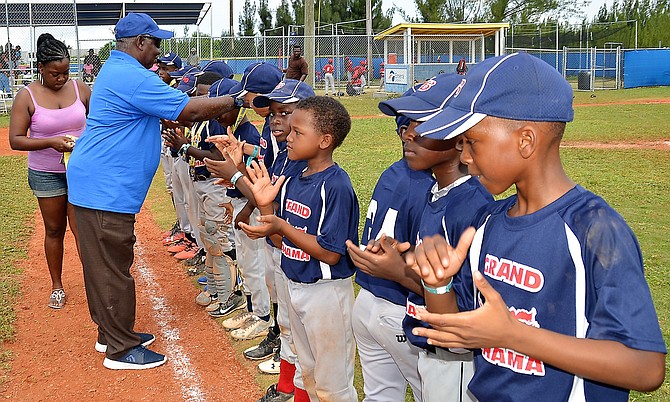 BBA president Sam Rodgers presents medals to Grand Bahama Little League players. Photo: Dereck Carroll