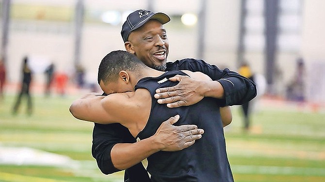 Coach Norbert Elliot embraces a student athlete at Purdue University, where he will head the Boilermakers' track and field programme.