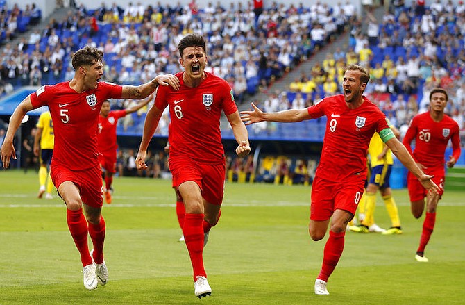 England's Harry Maguire, centre, celebrates with his teammates after scoring his side's opening goal during the quarterfinal match between Sweden and England. (AP Photo/Francisco Seco)

