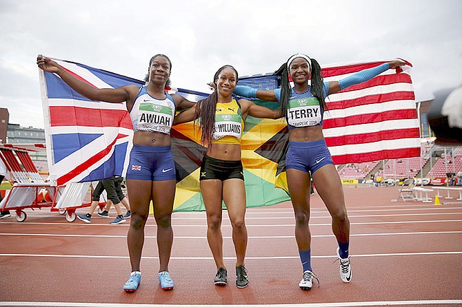 Third-place finisher Kristal Awuah, left, of Great Britain, winner Briana Williams, centre, of Jamaica and second-place finisher Twanisha Terry, of the United States, celebrate after the women's 100 metres at the 2018 IAAF World U20 Championships in Tampere, Finland, Thursday, July 12, 2018. (Kalle Parkkinen/Lehtikuva via AP)