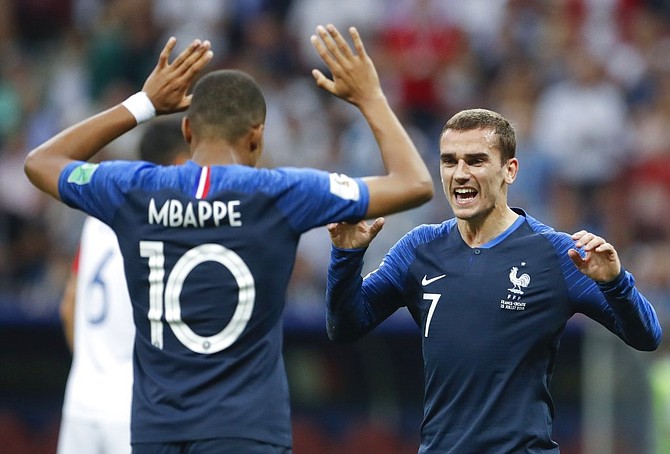France's Antoine Griezmann celebrates with his teammate Kylian Mbappe, left.