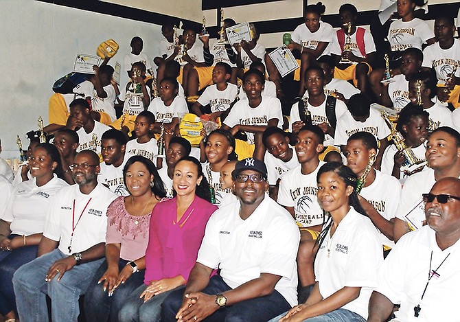 SUMMER CAMP: Shown in the front row are Kevin Johnson Basketball Camp coaches, third from left, Janae Rolle, sales specialist, CIBC FirstCaribbean Marathon Mall branch, Nikia Christie, marketing manager, CIBC FirstCaribbean, and coach Kevin Johnson, founder, The Kevin Johnson Basketball Camp. Seated behind Nikia Christie is Vandia Williams, scholarship winner as well as the awardee for overall team champion, free-throw champion and most-improved player. 
